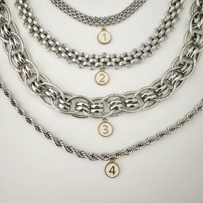 Quatro correntes metálicas prateadas com padrões diferentes e medalhões numerados 1 a 4