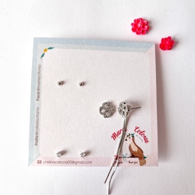 Conjunto de brincos prata variados em cartão branco com ilustração e texto Maria Cotovia