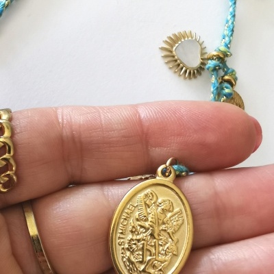 Colar com pendente oval dourado de São Miguel e cordão azul claro com detalhes dourados