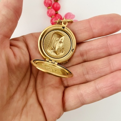 Colar com medalhão dourado aberto mostrando a Virgem Maria em relevo