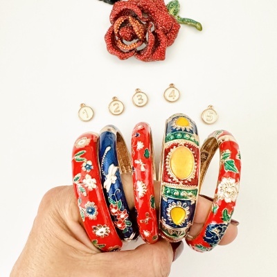 Cinco pulseiras coloridas com padrão floral e pendentes numerados