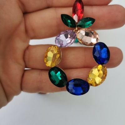 Broche redondo com pedras coloridas facetadas