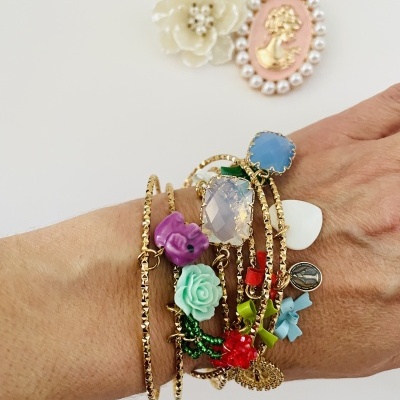 Várias pulseiras coloridas e broches decorativos sobre fundo branco