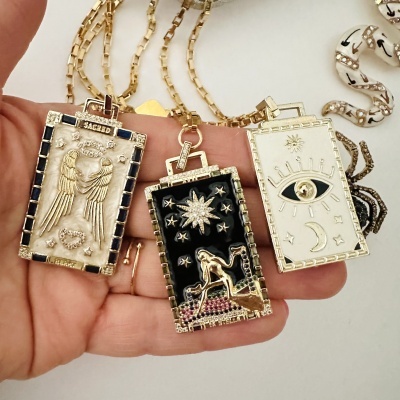 Colares com pendentes retangulares dourados decorados com esmalte e símbolos diversos