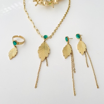 Conjunto de joias douradas com folhas e pedras verdes