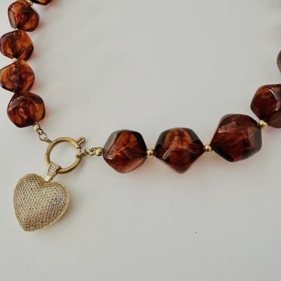 Colar castanho com contas e pendente de coração dourado.