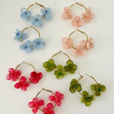 Brincos argola com flores de resina coloridas em fundo branco