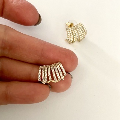 Brincos dourados com pedras brilhantes em fundo branco