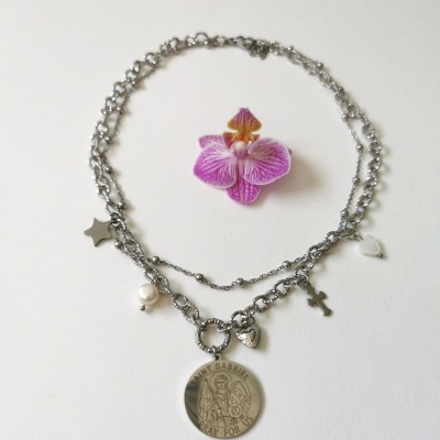 Colar prateado com pingentes variados e uma flor roxa ao centro.