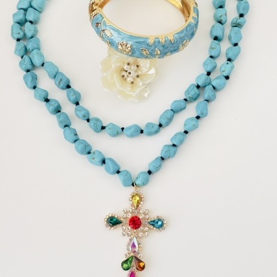 Colar de contas azuis com pendente de cruz colorida e pulseira dourada com flor