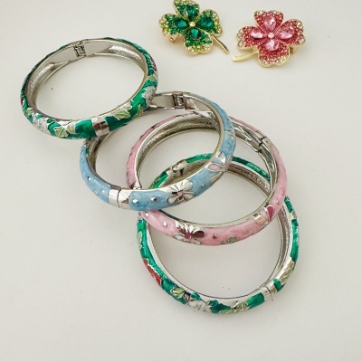Pulseiras esmaltadas coloridas com flores e presilhas em forma de trevo com pedras.
