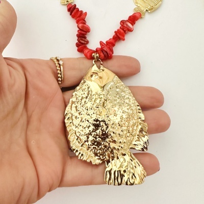 Colar com pedras vermelhas e pendente dourado em forma de peixe segurado por mão com anéis