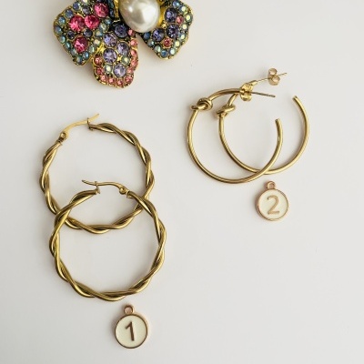 Dois pares de brincos dourados de aro com etiquetas numeradas e flor decorativa colorida