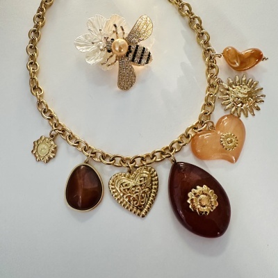 Colar dourado com pendentes variados e broche de abelha com pérola