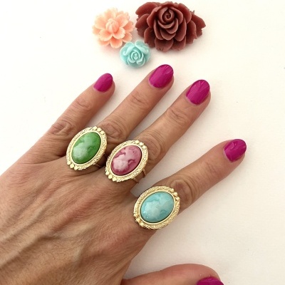 Mão com anéis de pedras coloridas e flores decorativas