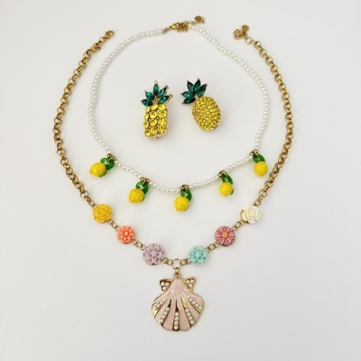 Conjunto de bijuterias com colares e brincos coloridos e decorativos sobre fundo branco
