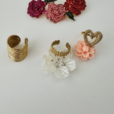 Anéis e pulseiras douradas com strass e decoração floral
