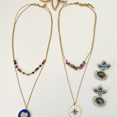 Conjunto de joias com colares, brincos, pulseiras e broche em fundo branco