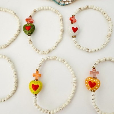 Pulseiras com contas brancas e corações coloridos