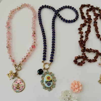 Colares com contas rosas, azuis e marrons com pingentes em metal dourado