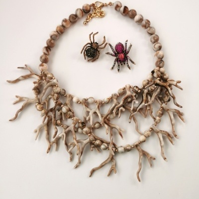 Colar bege com ramos entrelaçados e dois pendentes de aranhas brilhantes