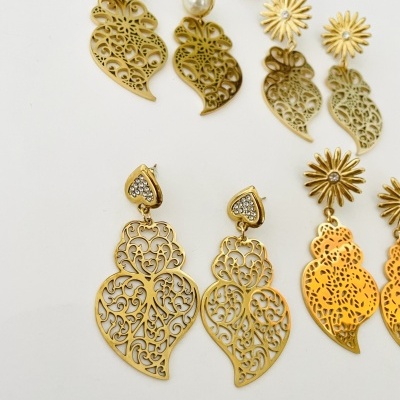 Cinco pares de brincos dourados com diferentes designs e detalhes em pérola e cristais