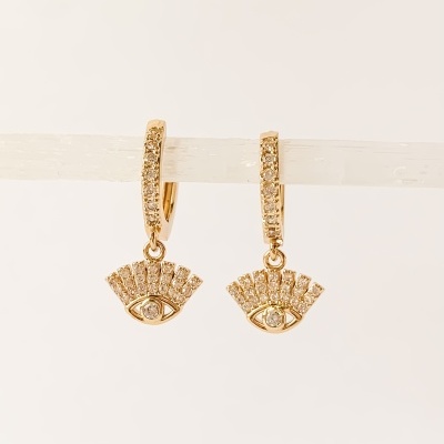 Brincos dourados com pendentes em forma de olho decorados com pedras