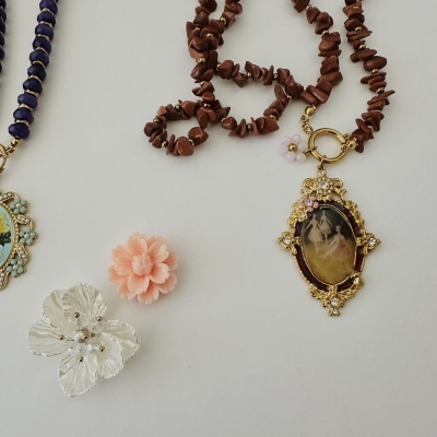 Colar de pedras castanhas com pendente dourado floral