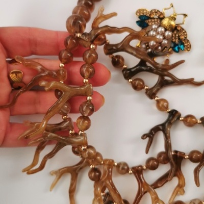 Colar com contas castanhas e elementos em forma de galho castanho claro