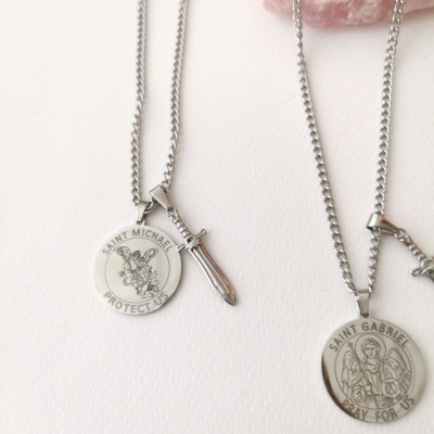 Colares prateados com pendentes de medalhões com inscrições e figuras religiosas