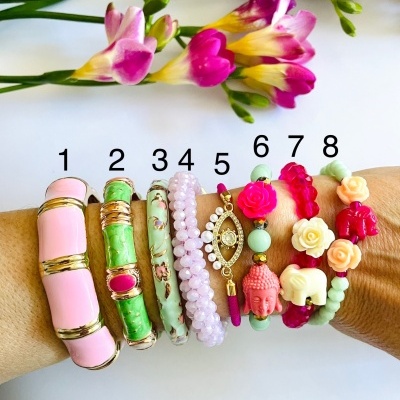 Oito pulseiras coloridas e numeradas num braço com flores coloridas ao fundo.