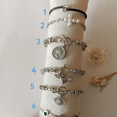 Seis pulseiras diferentes em suporte almofadado creme com números de 1 a 6