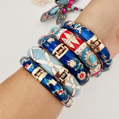 Sete pulseiras rígidas esmaltadas em azul e outras cores com padrões florais e geométricos