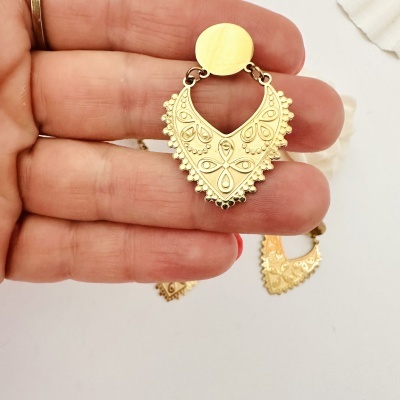 Brinco dourado em metal com padrão gravado e formato triangular