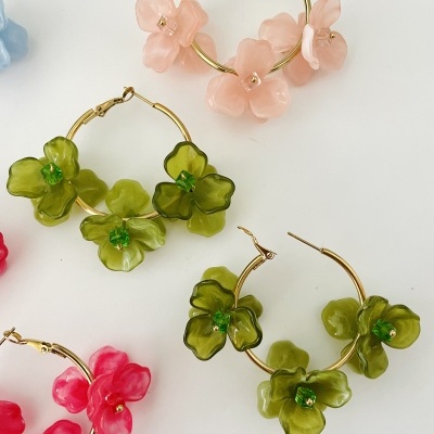 Argolas douradas com flores plásticas coloridas