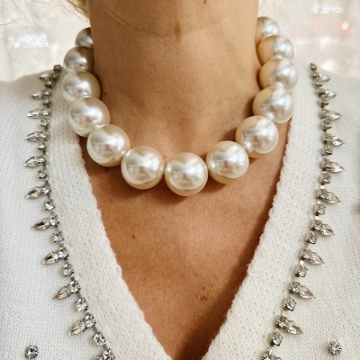 Colar de grandes pérolas brancas brilhantes com camisola branca decorada com cristais prateados