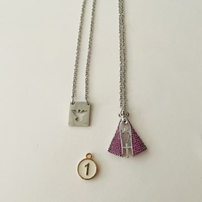 Colares com pendentes metálicos e um medalhão dourado com o número 1