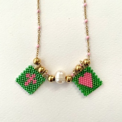 Colar com contas verdes e rosas em padrão de flor e coração com conta oval branca central