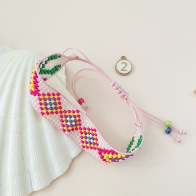 Pulseira colorida de contas em fio rosa com padrão geométrico
