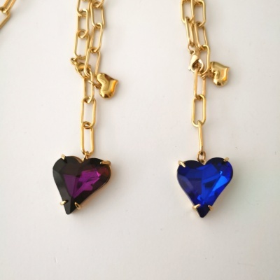 Dois colares com pendentes de coração em cristal azul e roxo escuro numa corrente dourada