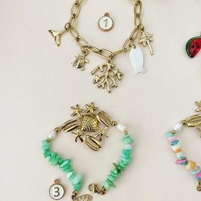 Duas pulseiras com pingentes variados, identificadas com etiquetas numeradas 1 e 3.