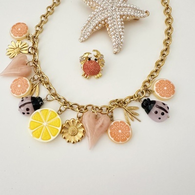 Colar com pendentes de frutas, corações, flores e joaninhas, broche de caranguejo e estrela-do-mar com pérolas