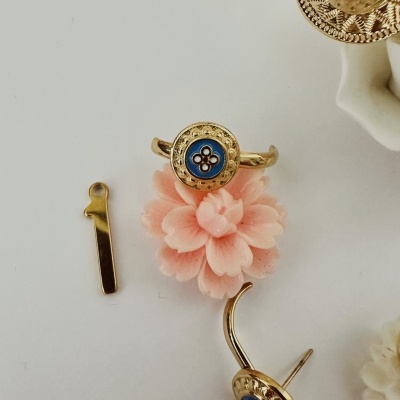 Conjunto de joias douradas com detalhes azuis e flores decorativas