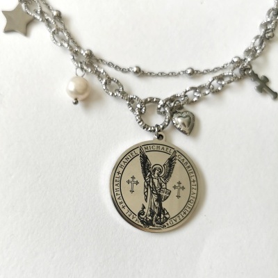 Colar prateado com medalhão redondo e vários pendentes sobre fundo branco