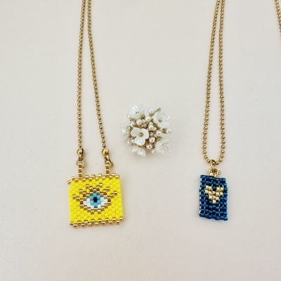 Colares em missangas com pendentes e broche com flores e pérolas