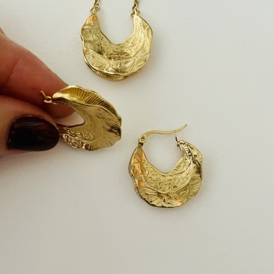 Conjunto de colar e brincos dourados com textura gravada.