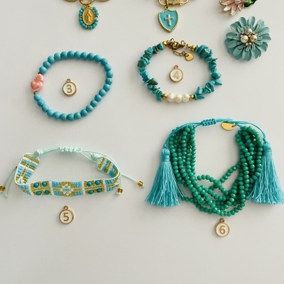 Seis pulseiras e dois acessórios florais em várias cores e materiais sobre fundo branco numerados de 1 a 6