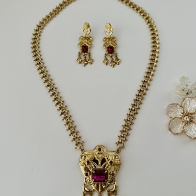 Conjunto de colar e brincos dourados com pedras vermelhas