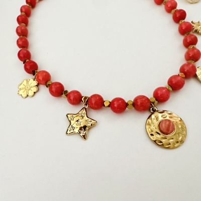 Colar vermelho com pendentes dourados em forma de flor, estrela e disco