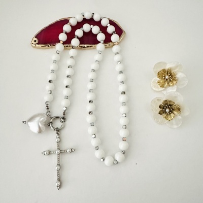 Colar branco com cruz e coração pendurado em suporte de pedra vermelha e brincos florais brancos com dourado